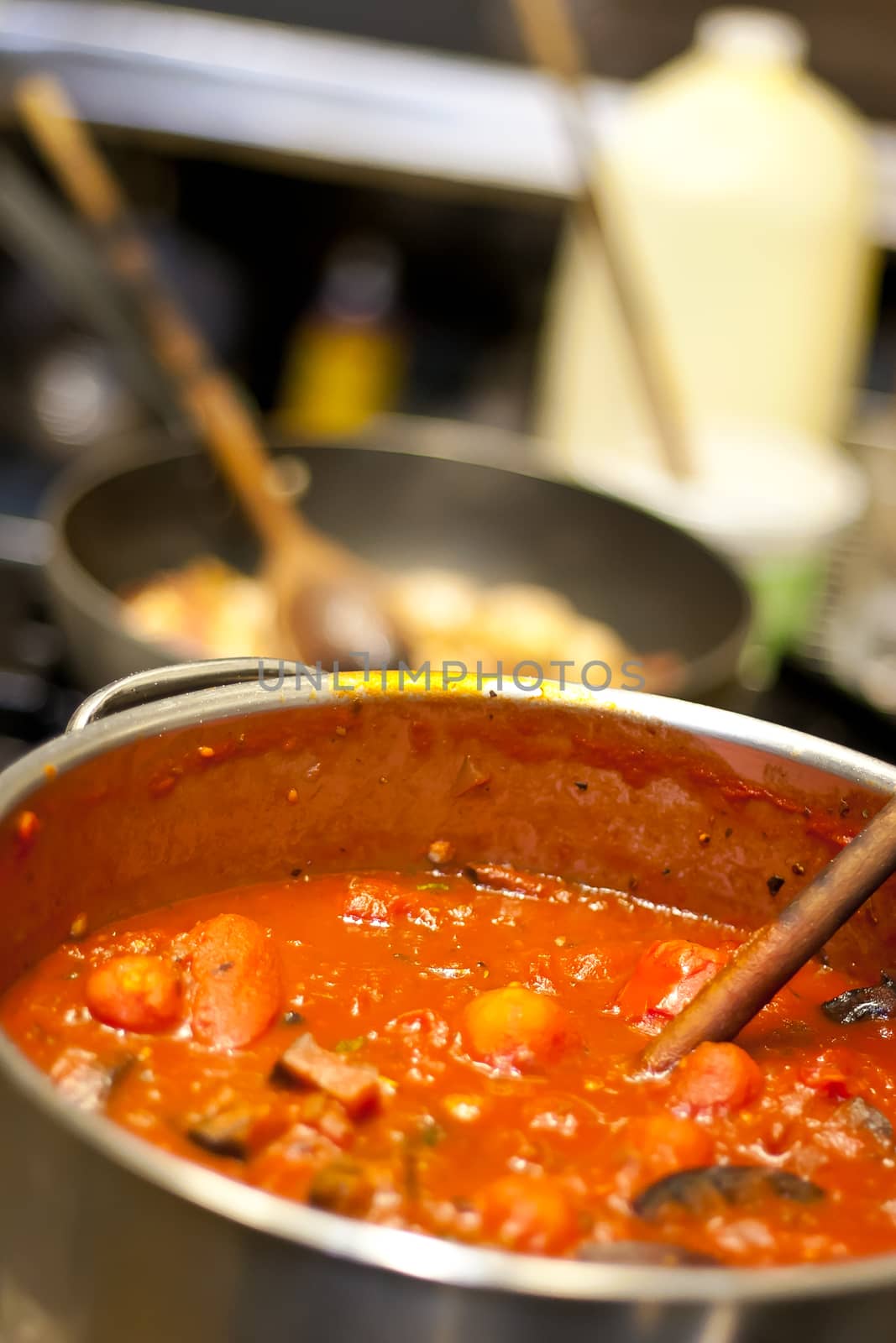 Tomato based pasta sauce simmering in a pot in a commercial kitchen at a pizza restaurant.