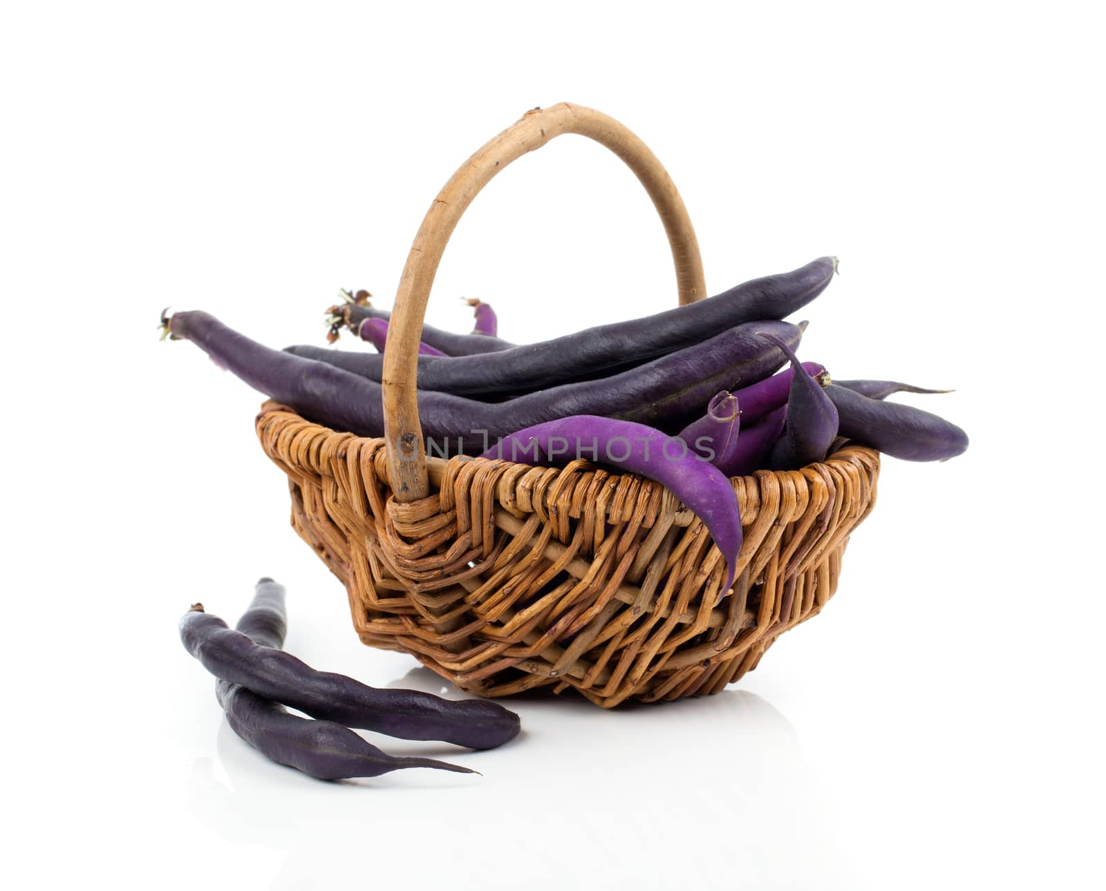 Red bean pods in wicker basket over white background