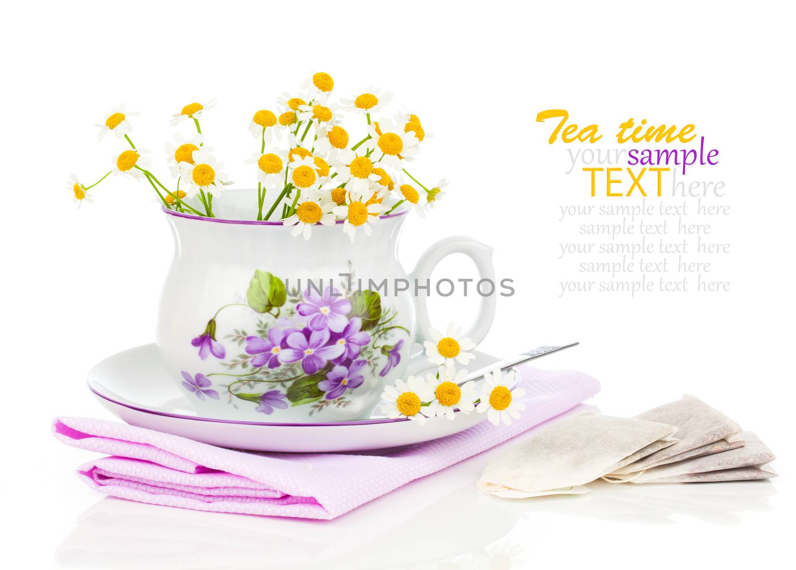 Cup with fresh camomile flower and tea bags, isolated on white by motorolka