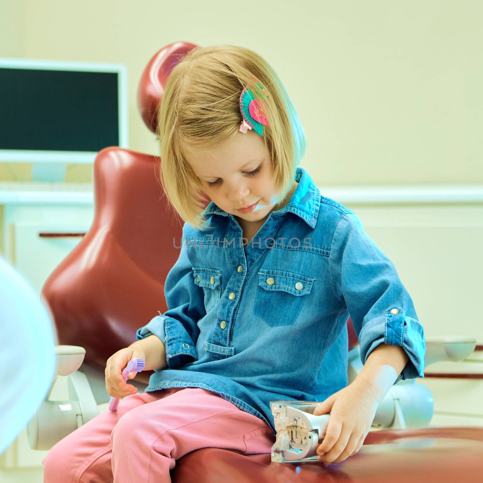 Little girl sitting in the dentists office by sarymsakov