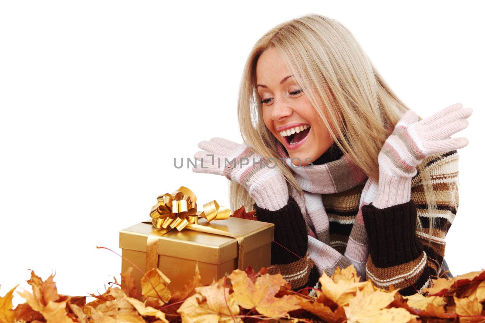 Woman with gift laying on dry autumn leaves isolated on white