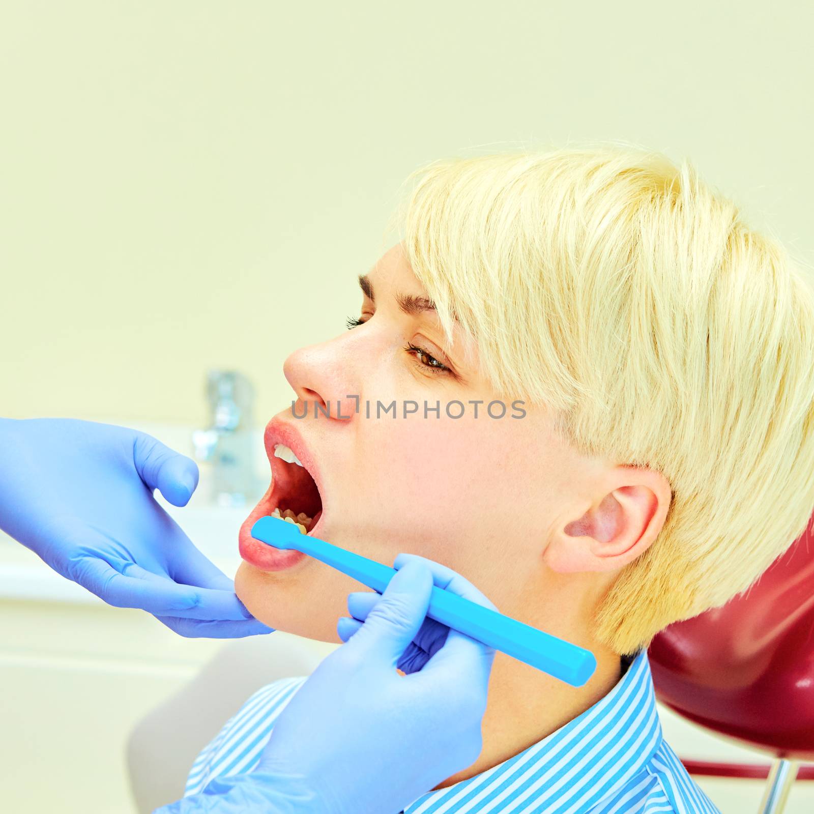 dentist brushing teeth to her patient in dental clinic
