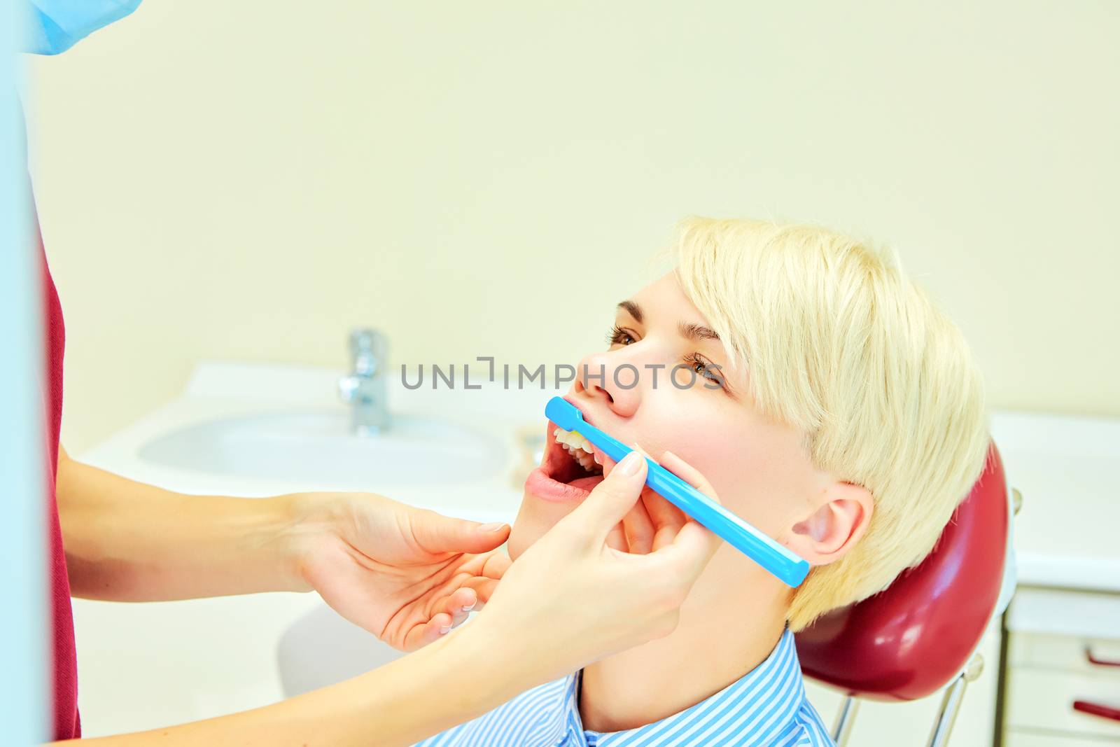 dentist brushing teeth to her patient in dental clinic