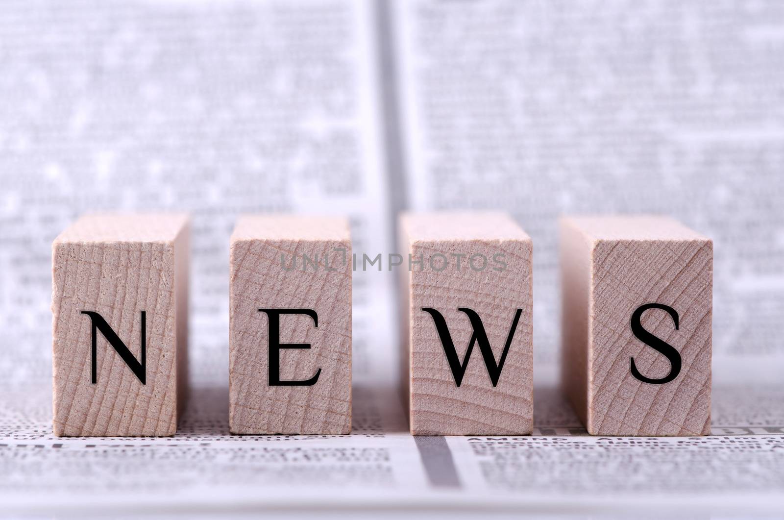 Four wooden blocks with word news written on. 