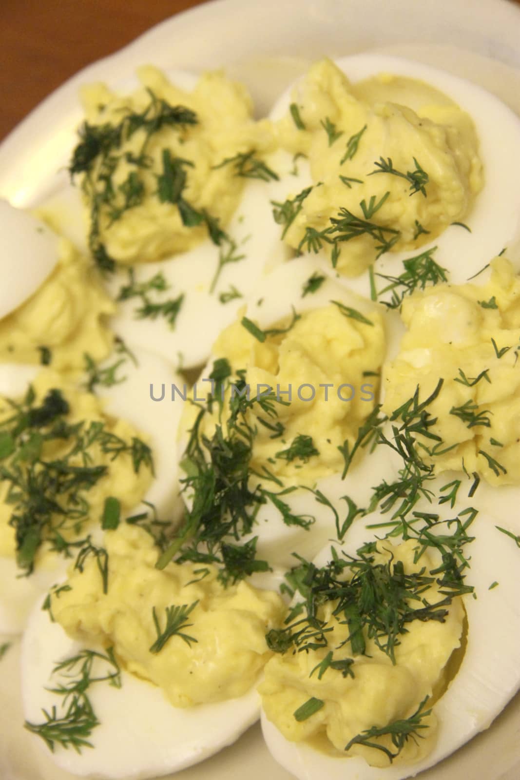 Boiled eggs sliced in halves stuffed and filling by pasta with dill