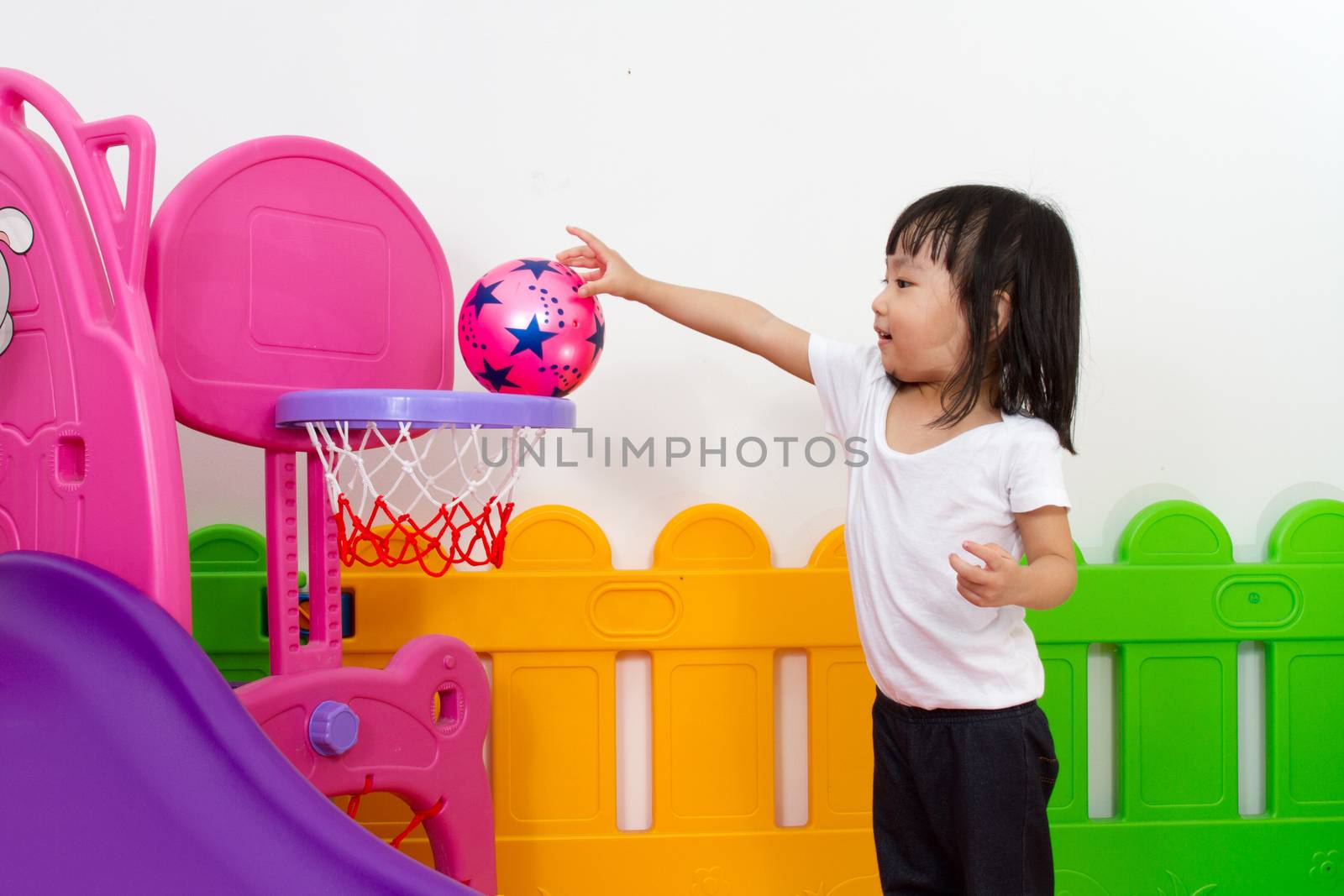Asian Chinese little girl playing basketball by kiankhoon