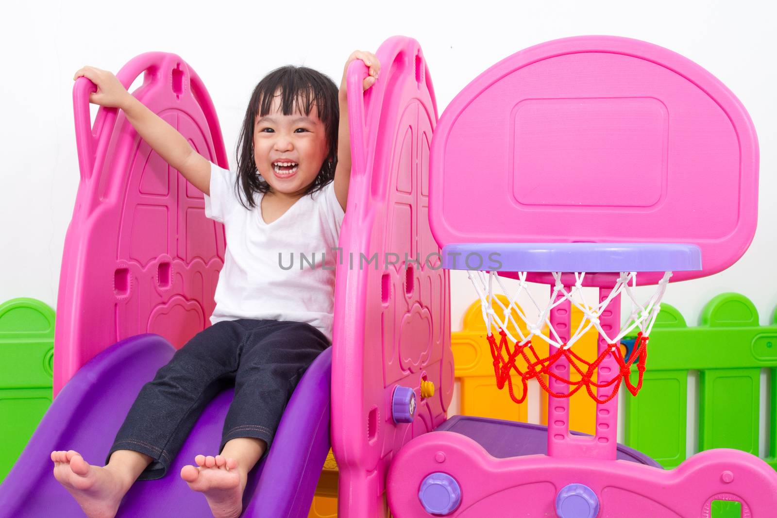 Asian Chinese little girl playing on the slide by kiankhoon