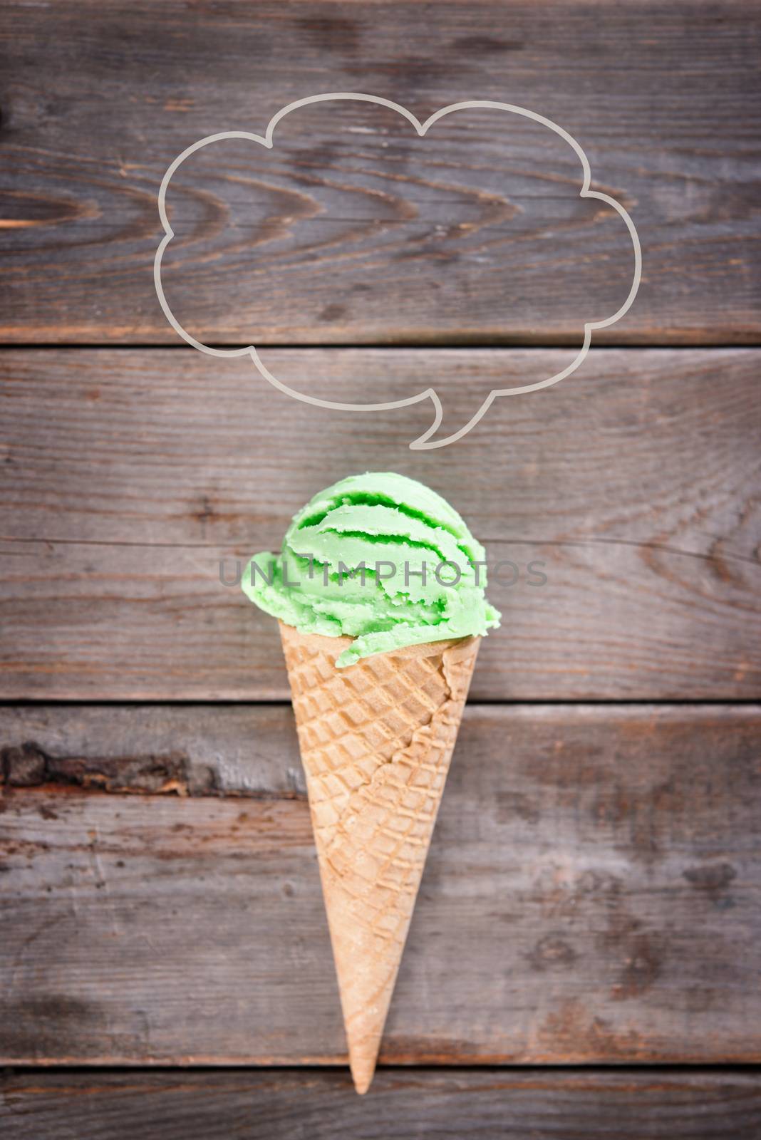 Single green tea ice cream in a waffle cone over old rustic wooden vintage background with copy space on top.