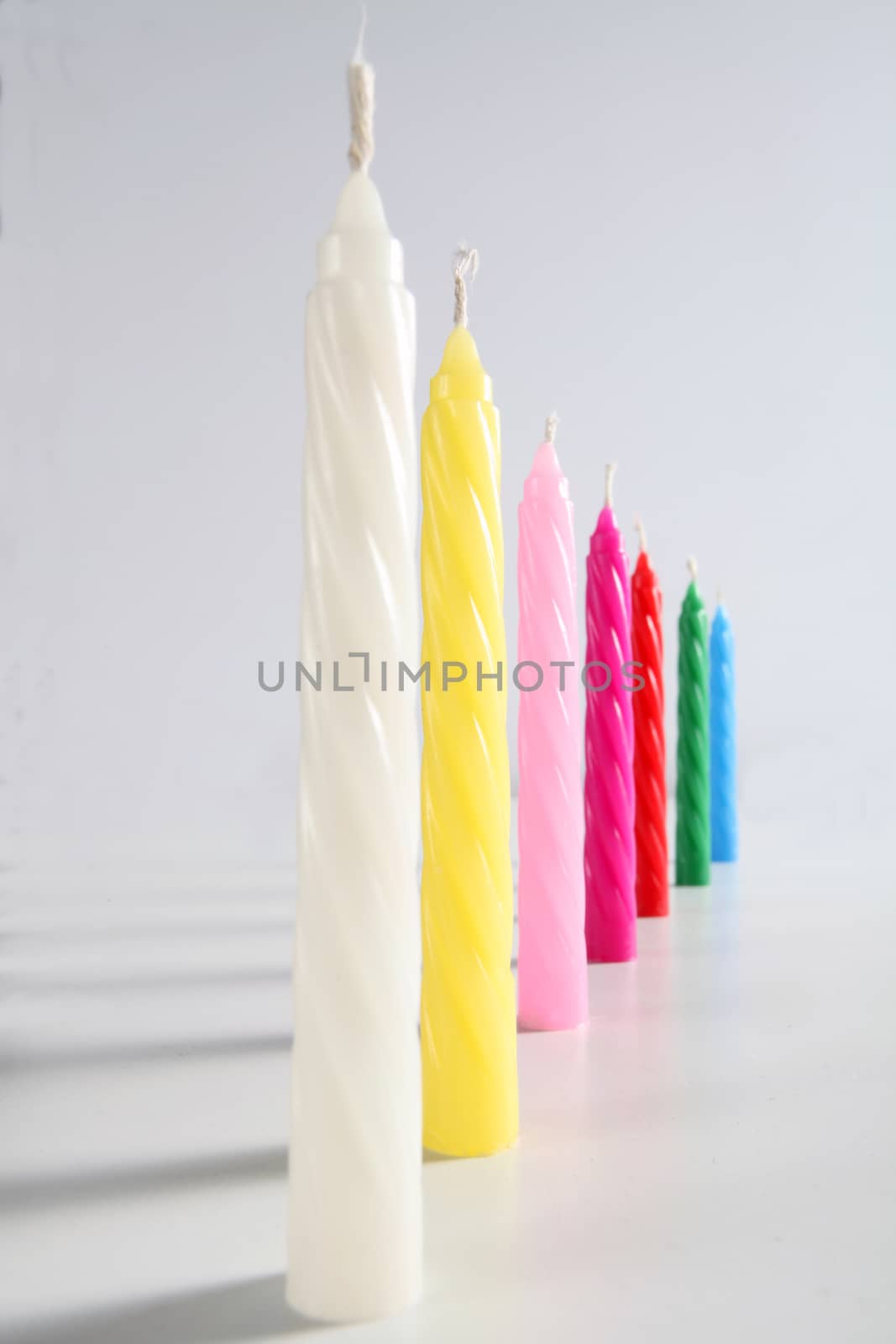 colored candles on white background by diecidodici