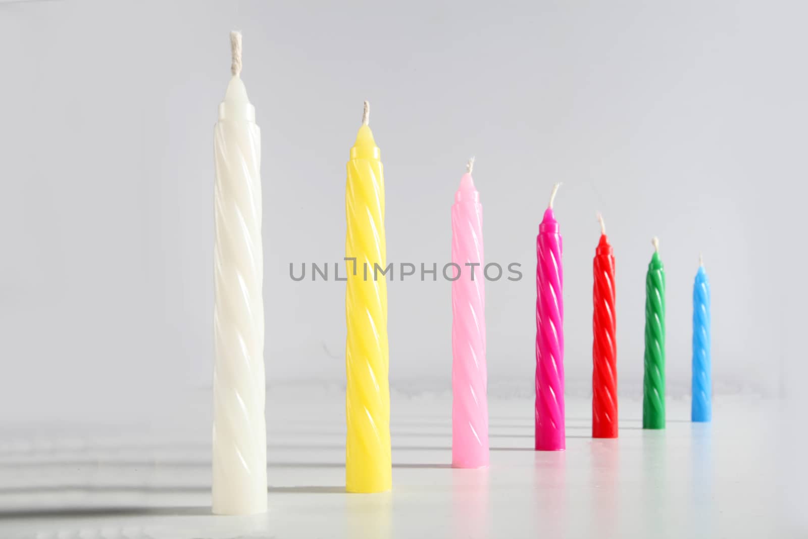 seven birthday colored candles on white background