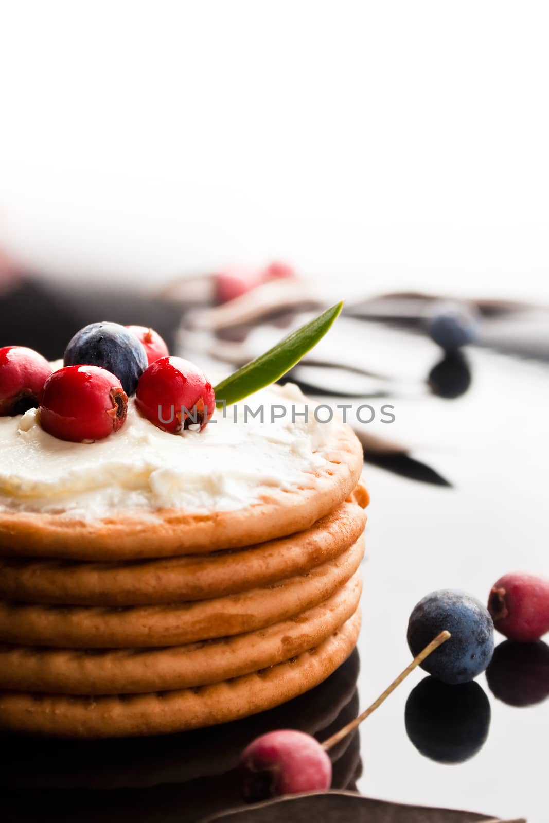  Cookies with cream cheese and blueberries on top surrounded with berries and dry leaves