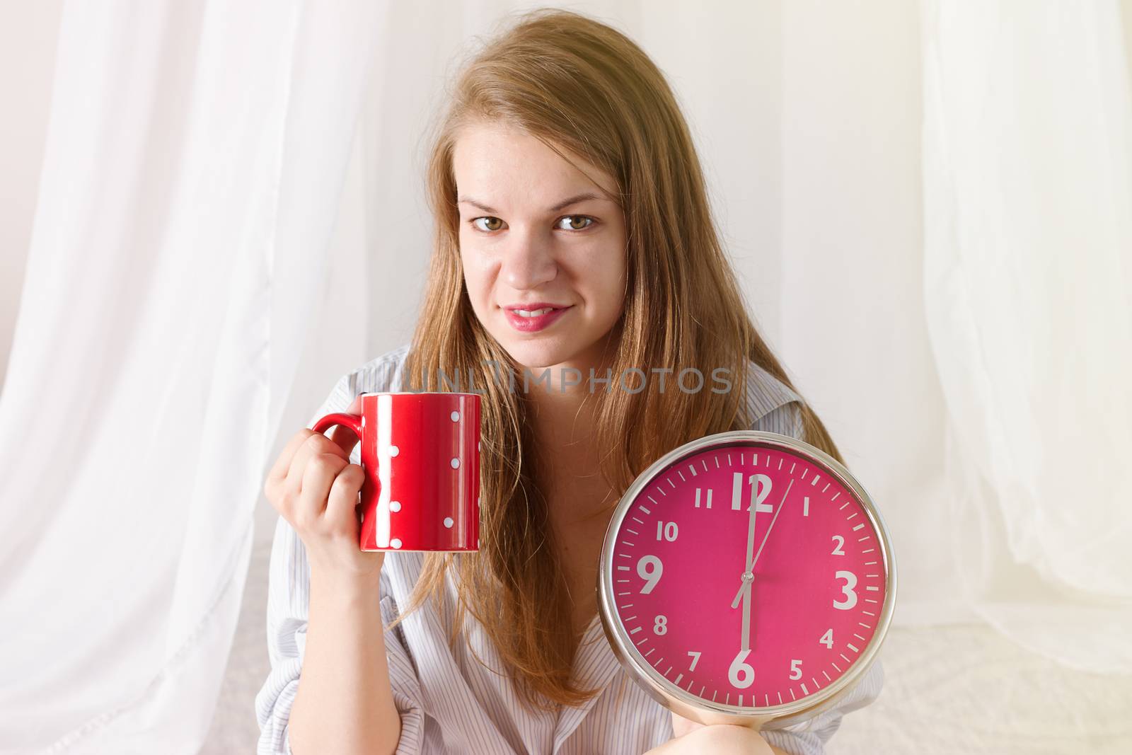 Happy girl  wake up , thumbs up with alarm clock and  coffee cup 6 a.m