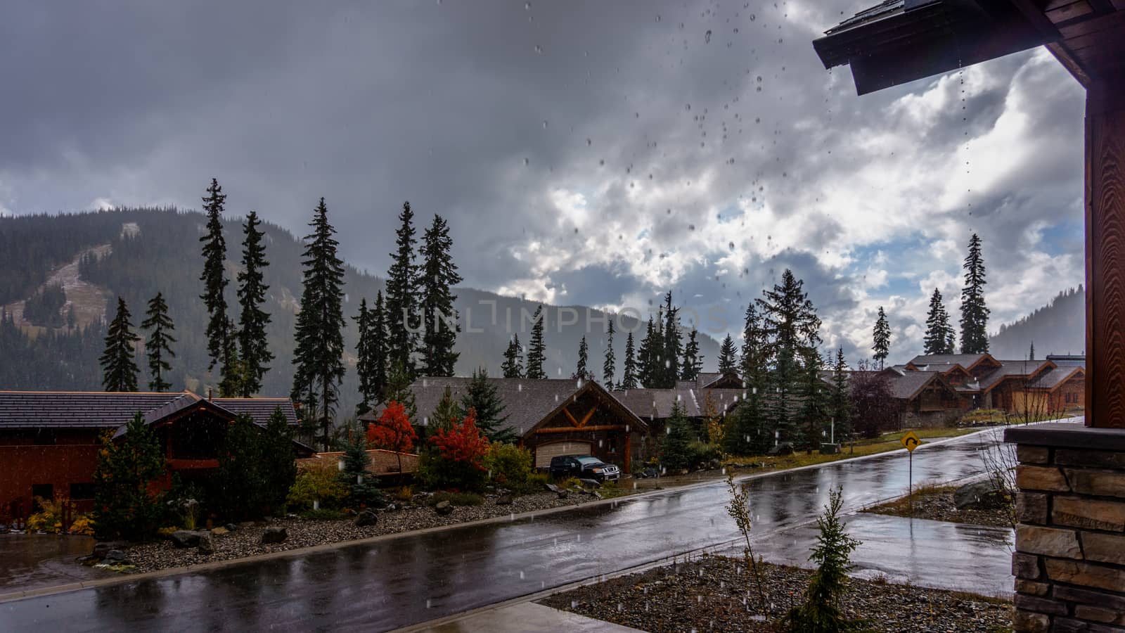 Raindrops falling from the Roof on a dark, cloudy, wet and rainy day in the mountain village of Sun Peaks on a cold autumn day