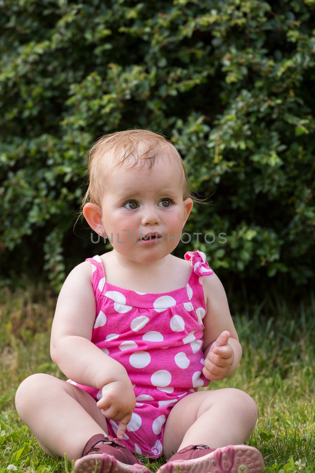 Happy cute little one year old girl outdoor, summer, with pink dress