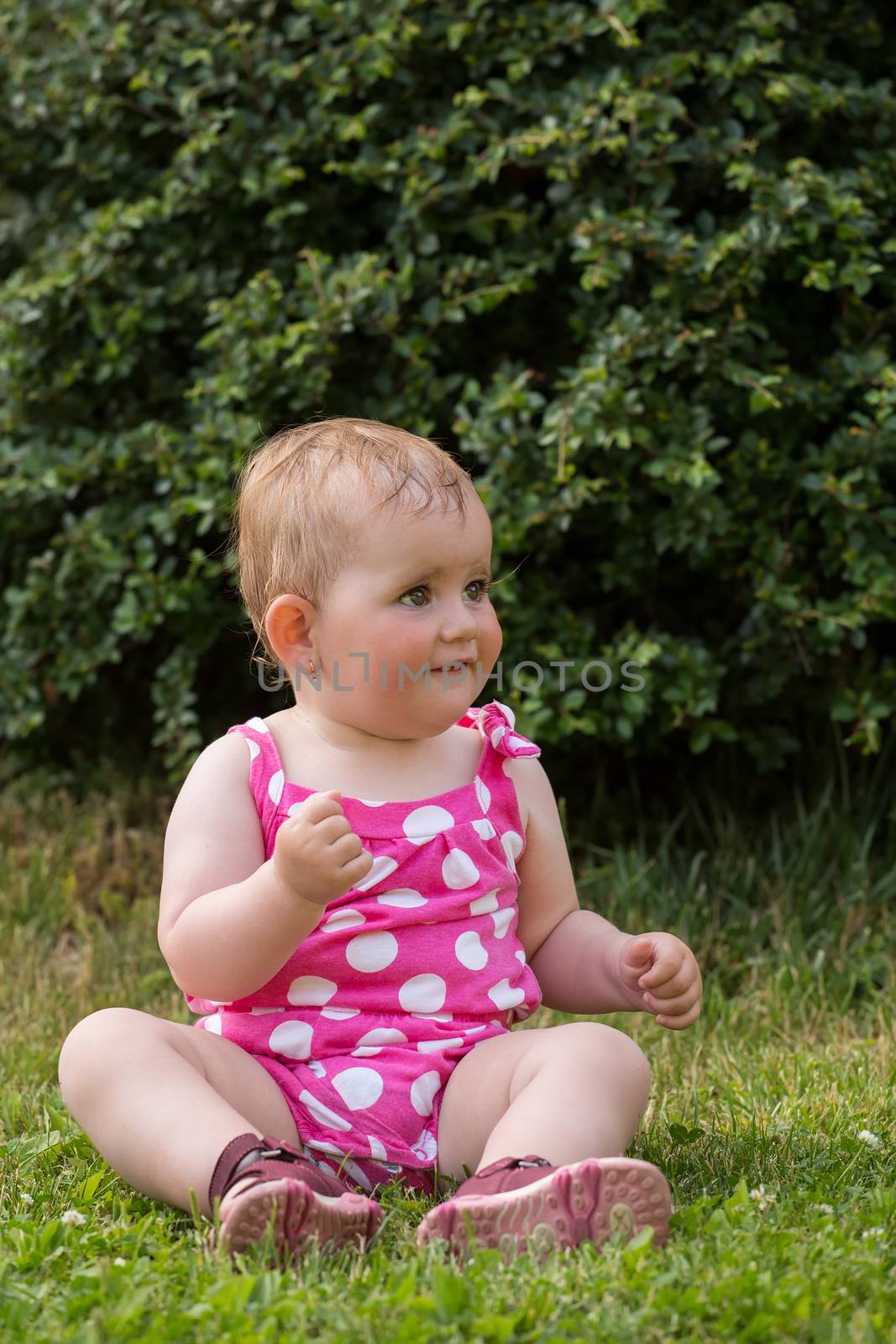 Happy cute little one year old girl outdoor, summer, with pink dress