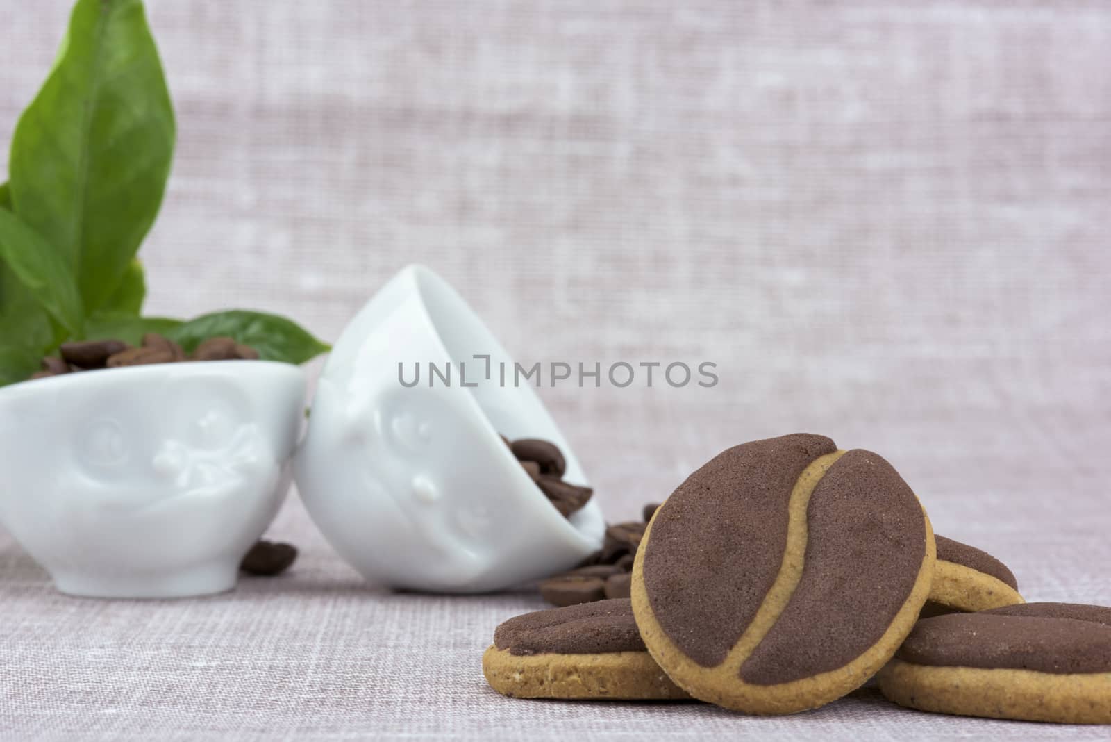 Delicious coffee cookies in the cute cups with facial expressions