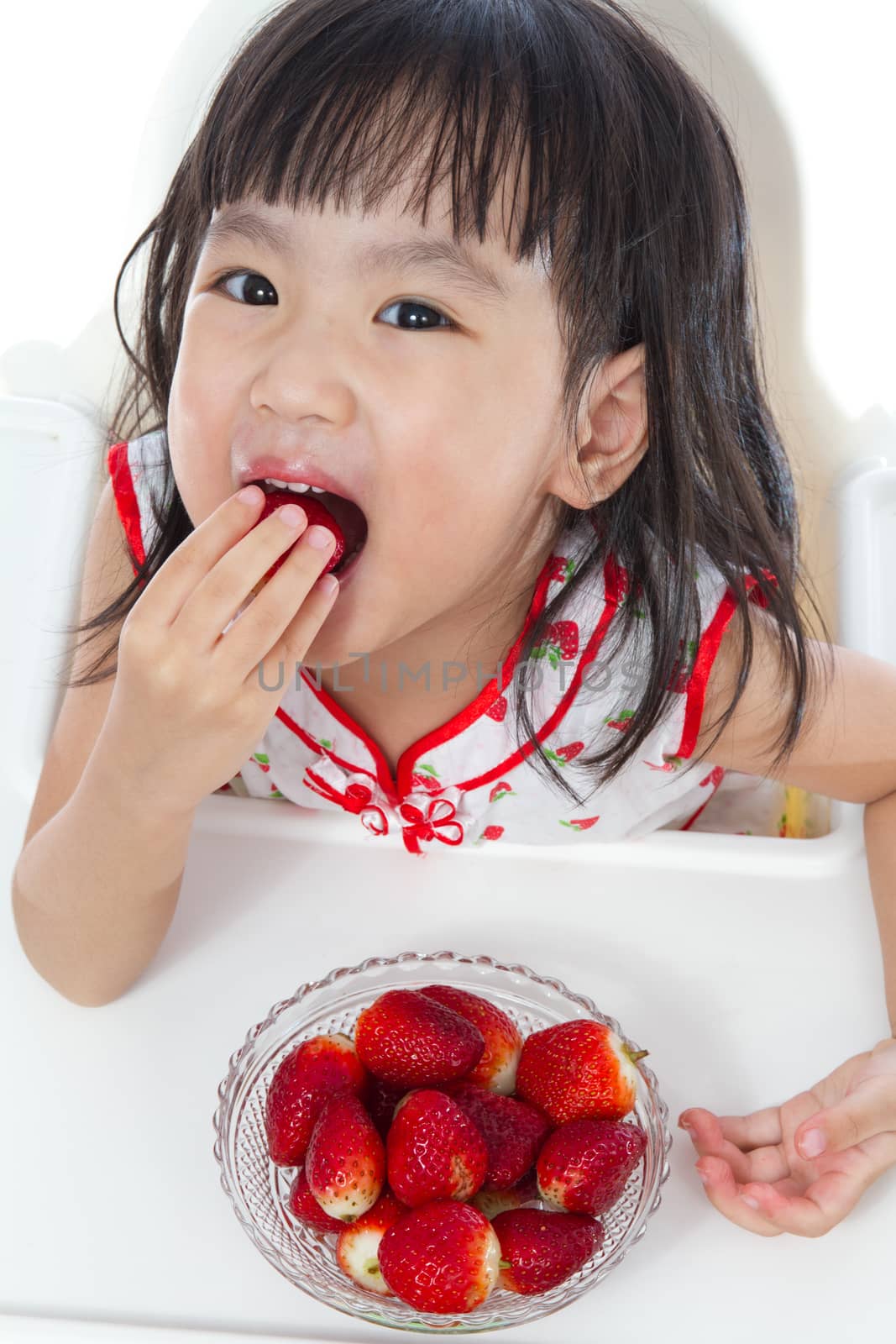 Asian Chinese children eating strawberries in plain white background.
