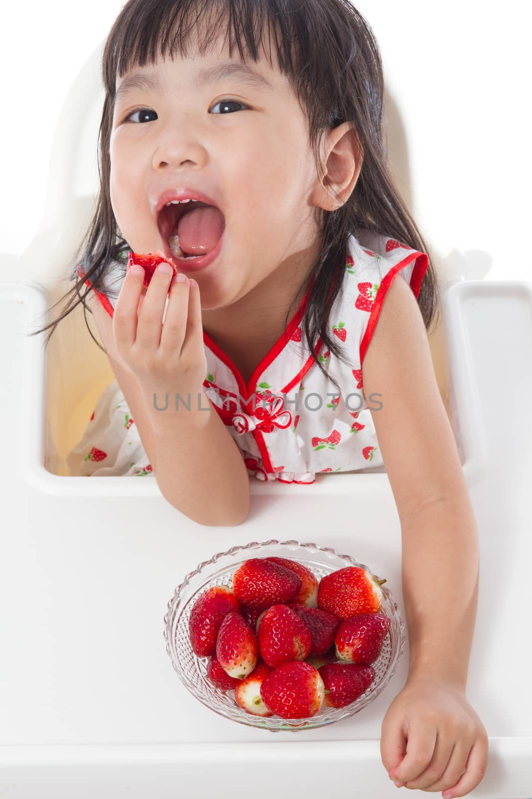 Asian Chinese little girl eating strawberries by kiankhoon