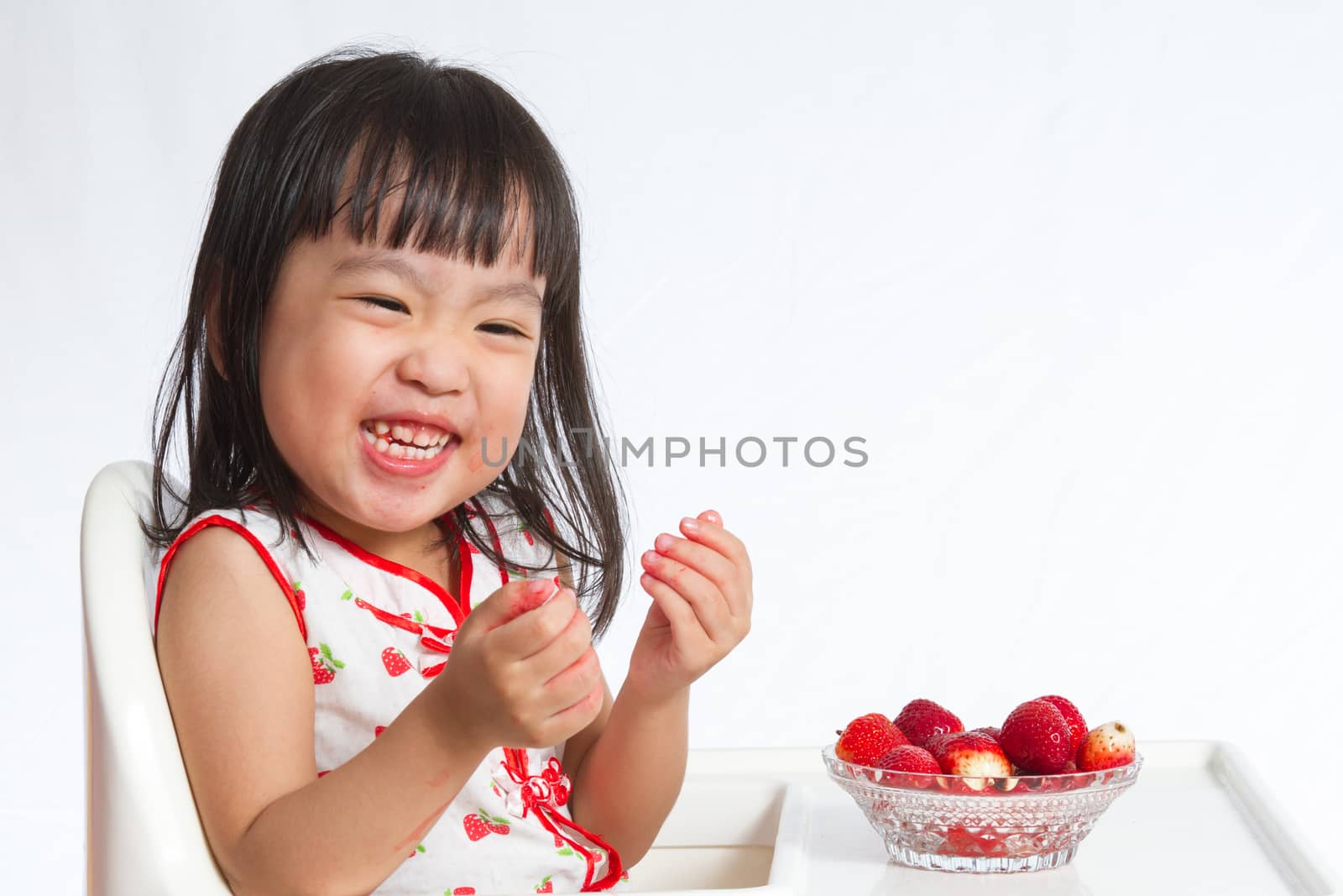 Asian Chinese children eating strawberries in plain white background.