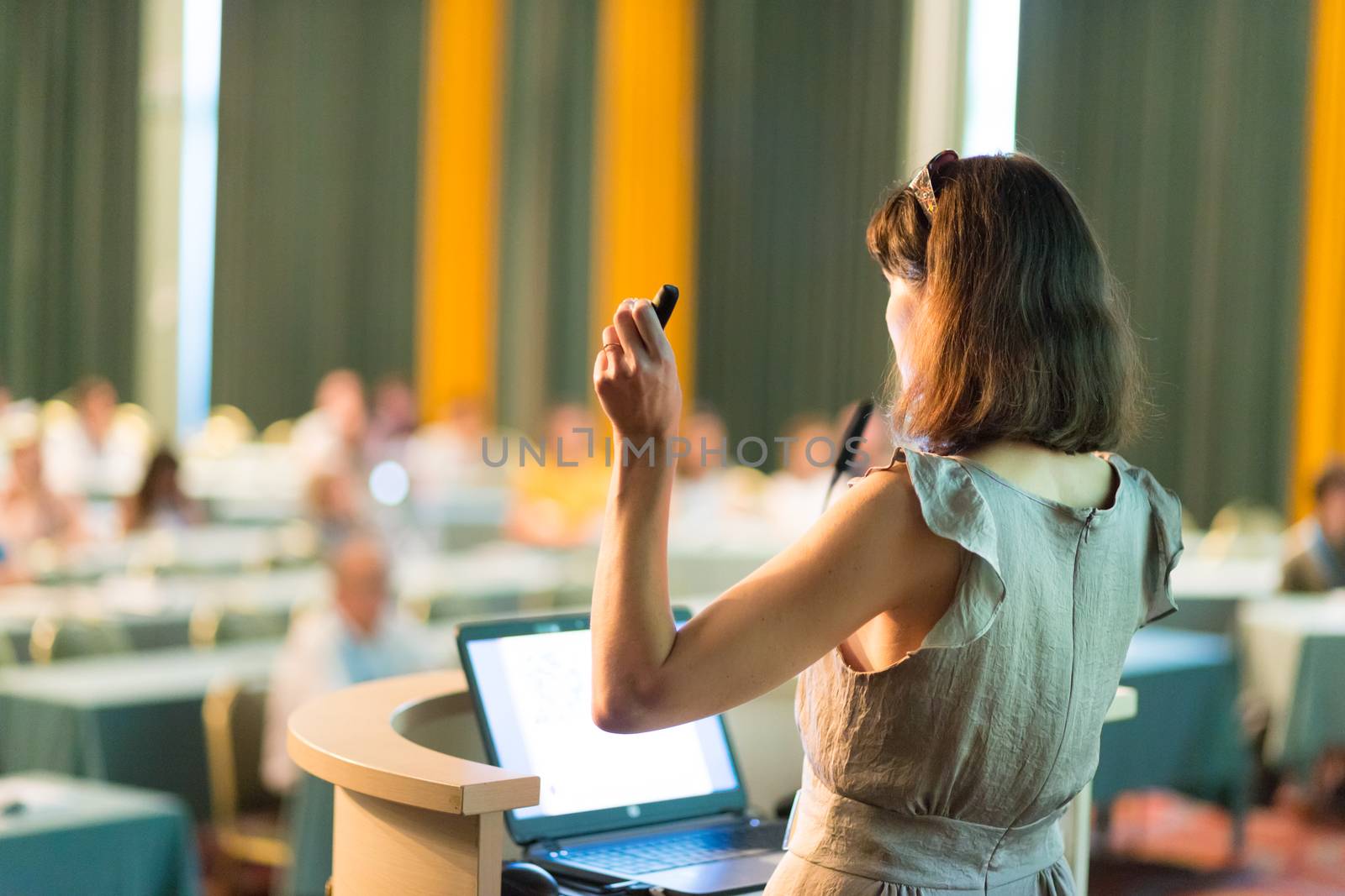 Business woman making business presentation. Female speaker giving a talk at  business conference . Business and Entrepreneurship concept. Brand copy space on white screen.