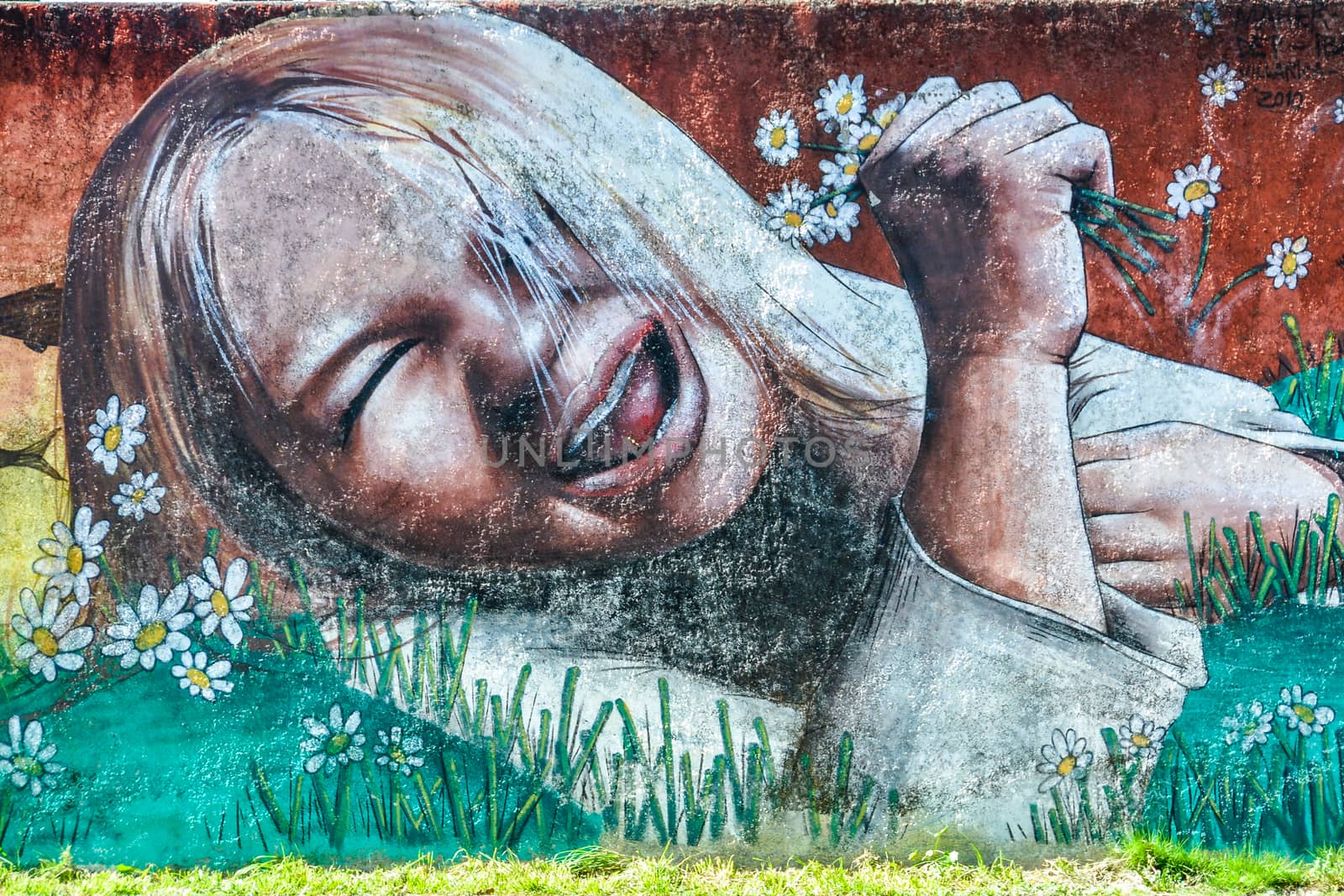 Graffiti of smiling girl holding flowers, Villarrica, Chile