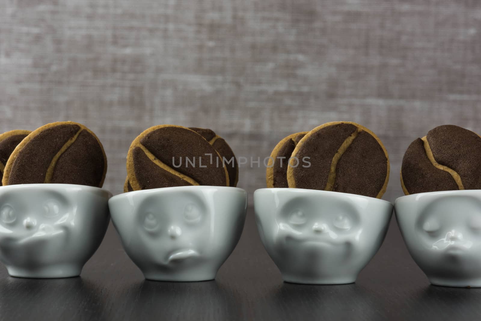 Delicious coffee cookies in a cute cups with facial expressions