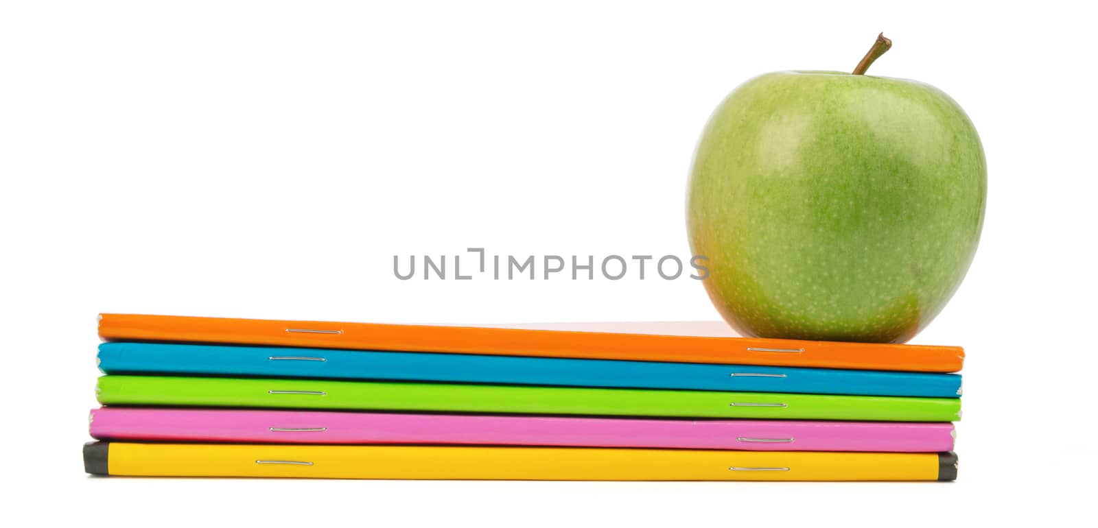 Fresh green apple with notebooks on isolated white background