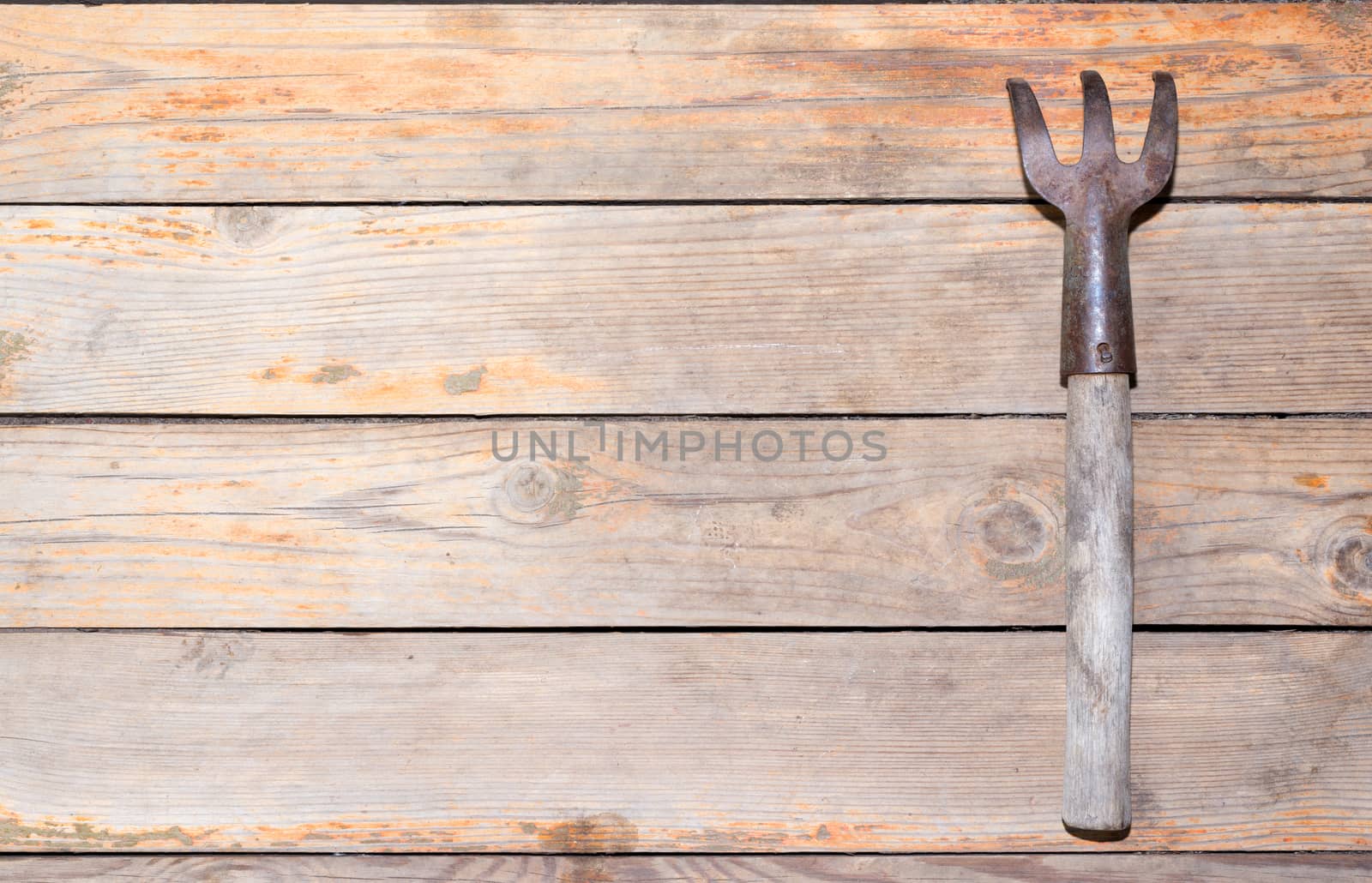 Old wooden texture background with rake, close up view