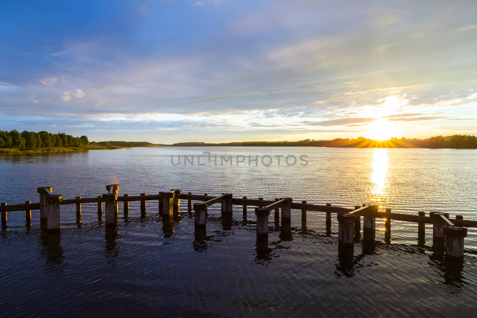 Landscape. Sunset on the shore of the pond in the summer.