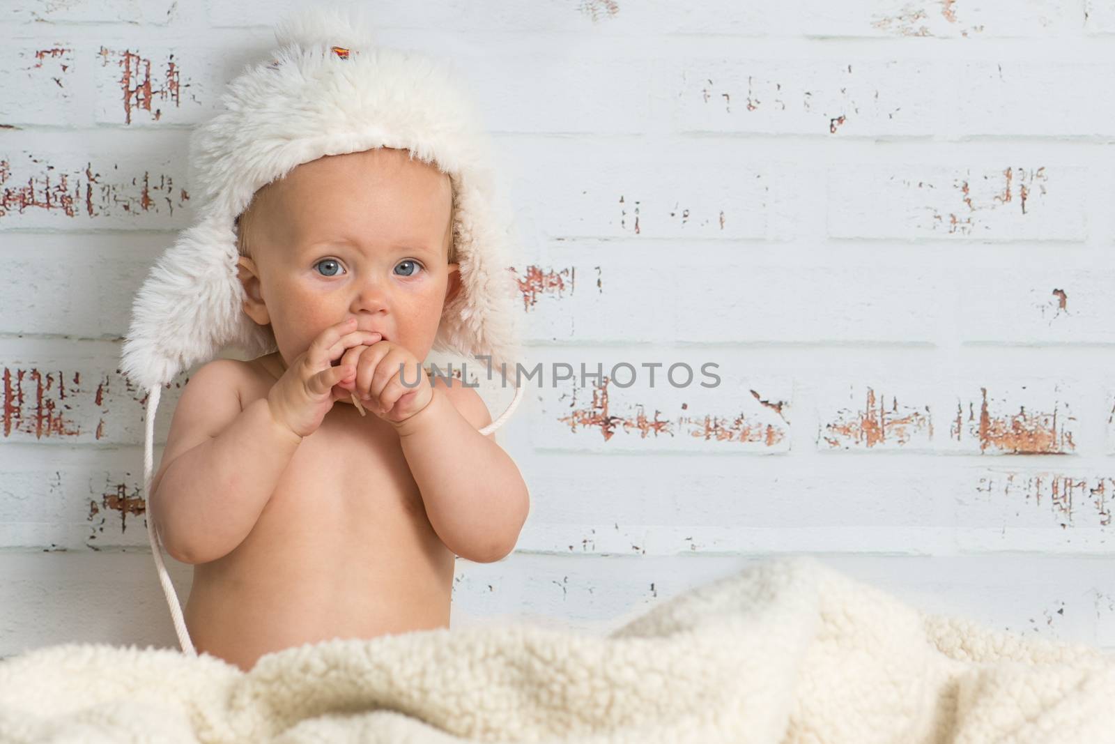  Baby girl in a cap enjoying warmth of the room by kamsta