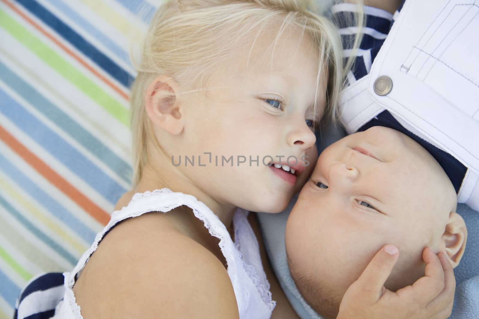 Cute Little Sister Laying Next to Her Baby Brother on Blanket.