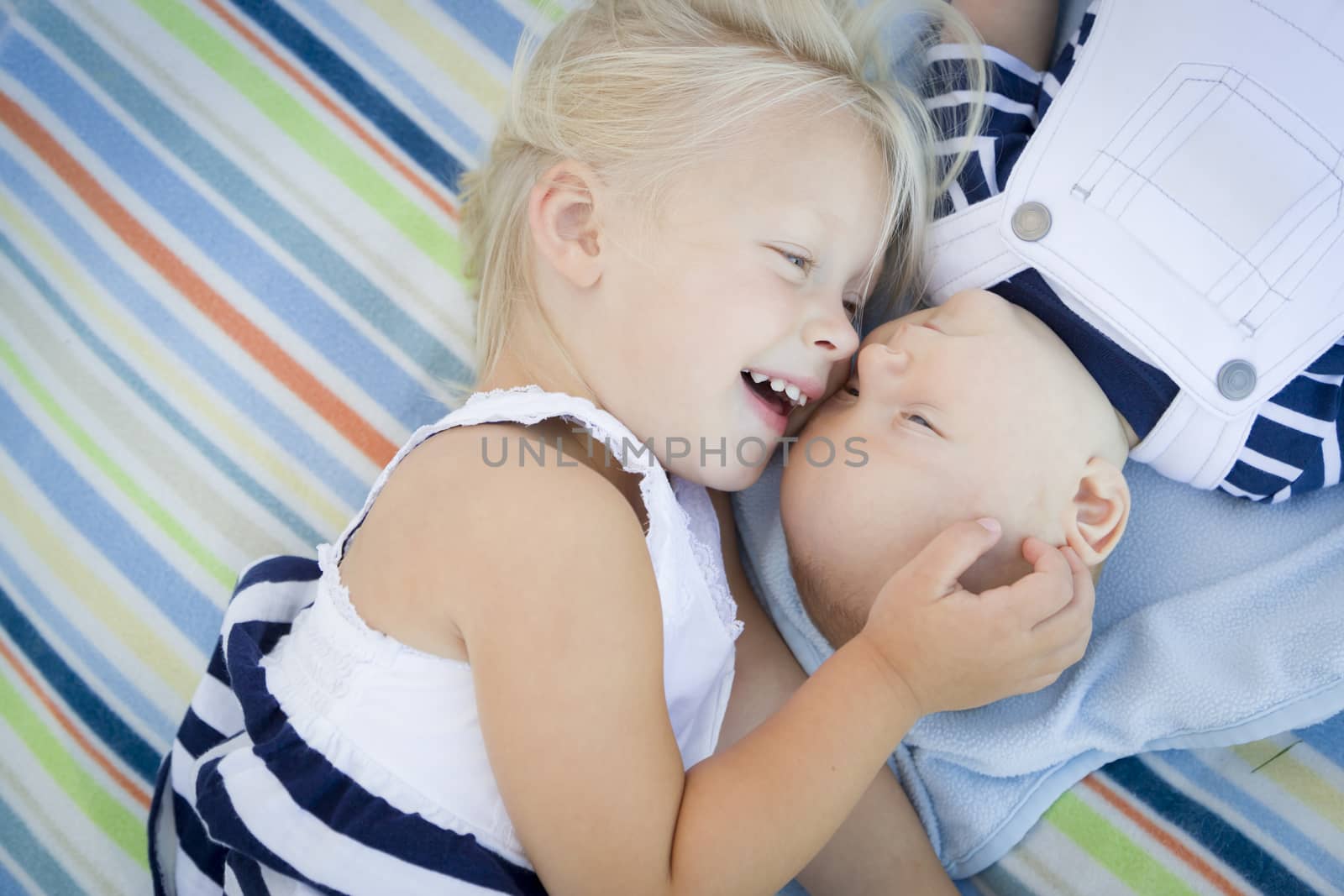 Little Sister Laying Next to Her Baby Brother on Blanket by Feverpitched