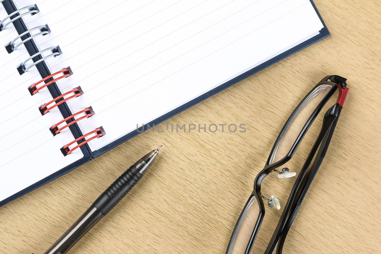 pen, glasses and blank opened notebook on the table by simpleBE