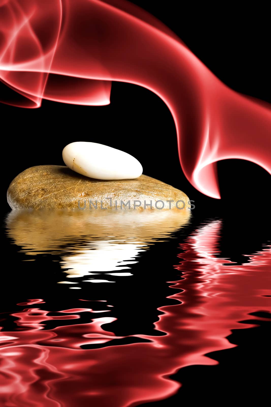 Zen stones surrounded by red smoke and reflected in the water.