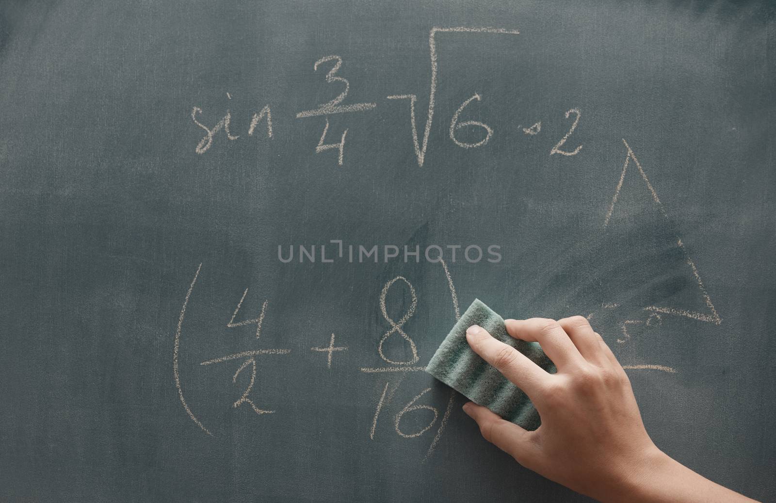 Hand of student studying mathematics and writing on a blackbroard