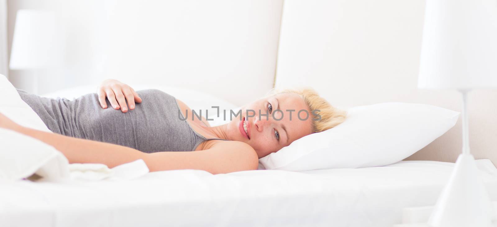 Young beautiful woman waking up fully rested with a smile on her face. Joy and happiness. Beauty sleep. Power nap.