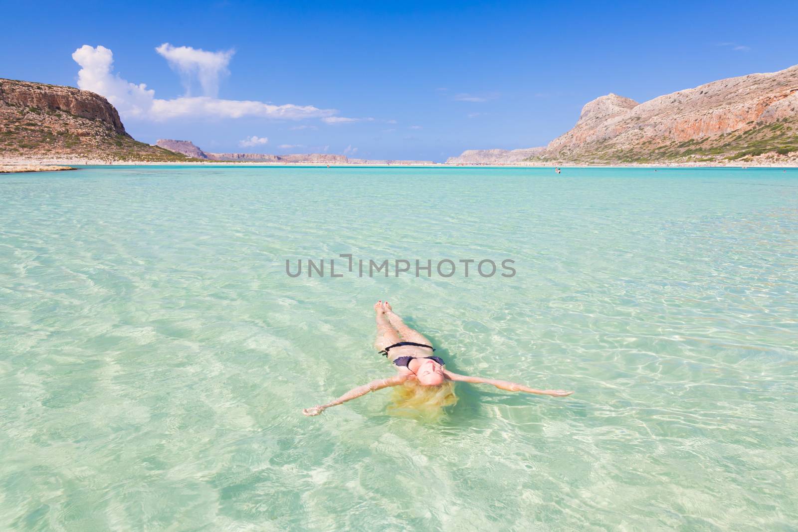 Beautiful Caucasian woman floating in turquoise blue lagoon.