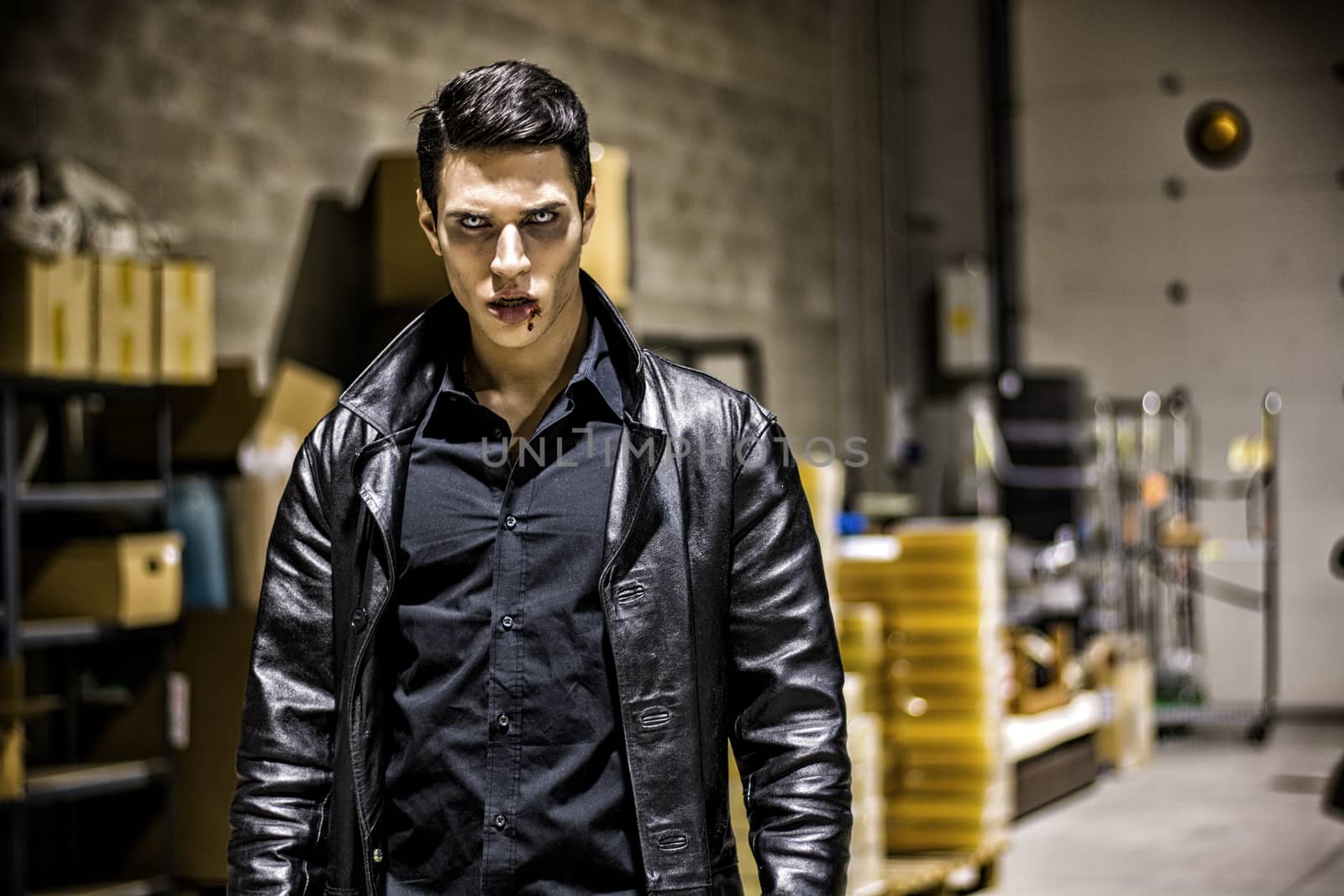 Close up Face of a Handsome Vampire Man in Leather Clothing, with Blood on his Mouth, Looking at the Camera.