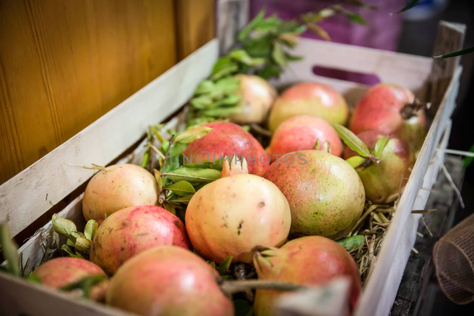 box of freshly picked pomegranates