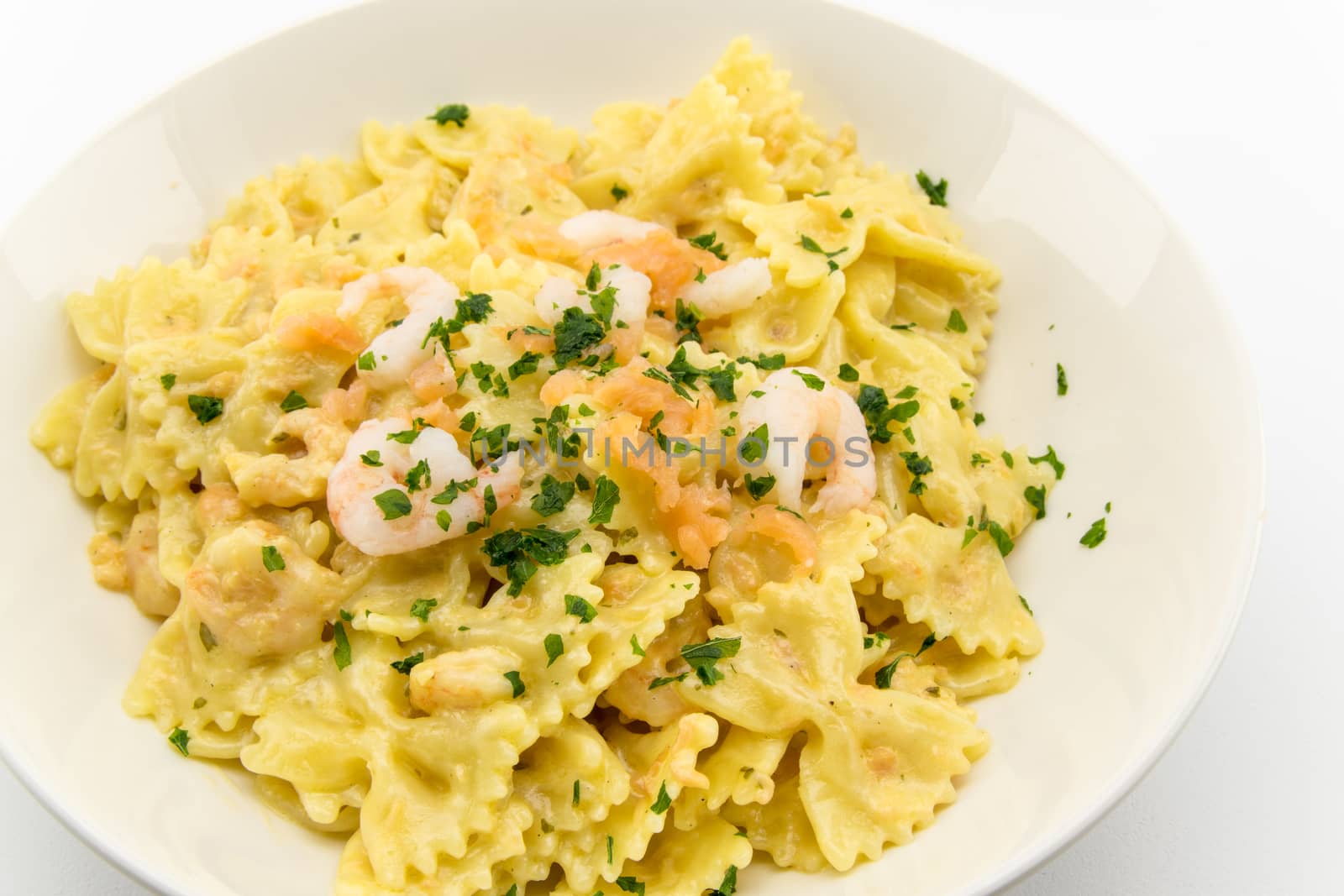 italian traditional pasta called butterflies with shrimp salmon and basil