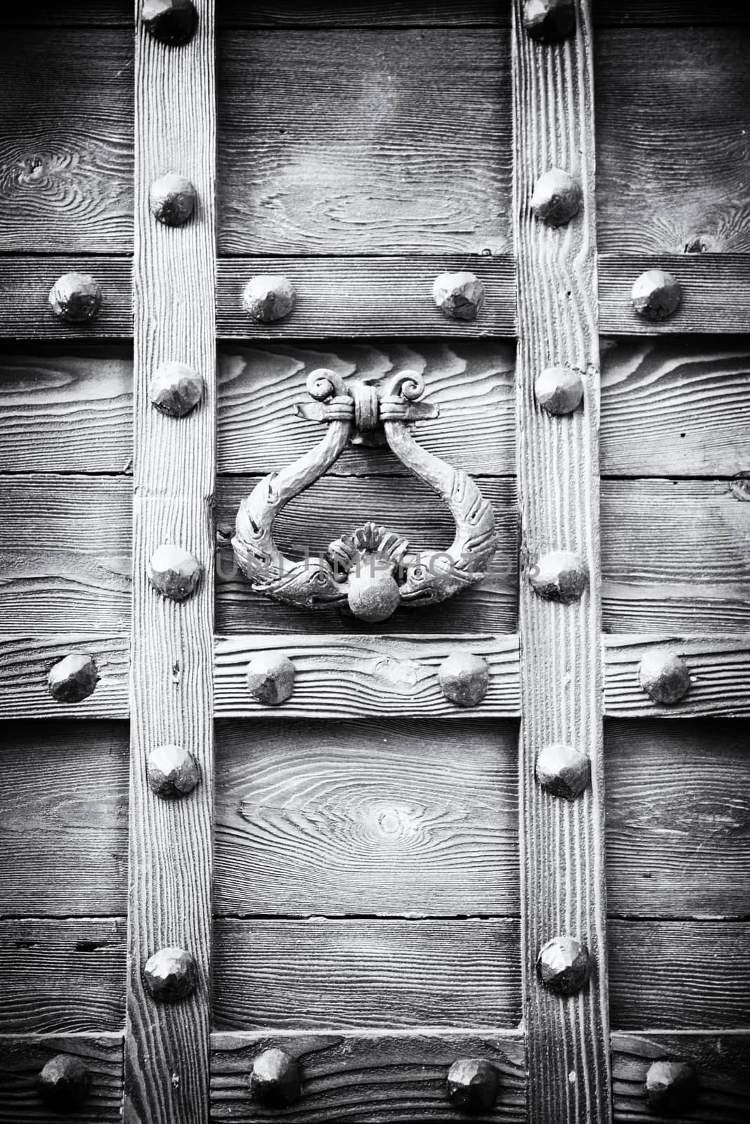 ancient door knocker of a medieval wooden portal