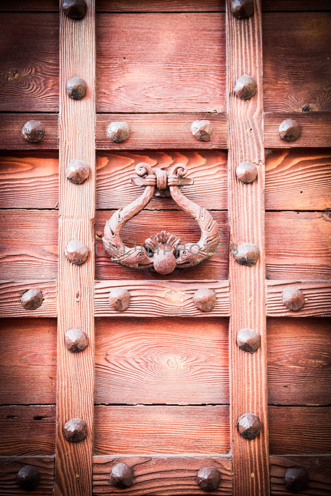 ancient door knocker of a medieval wooden portal