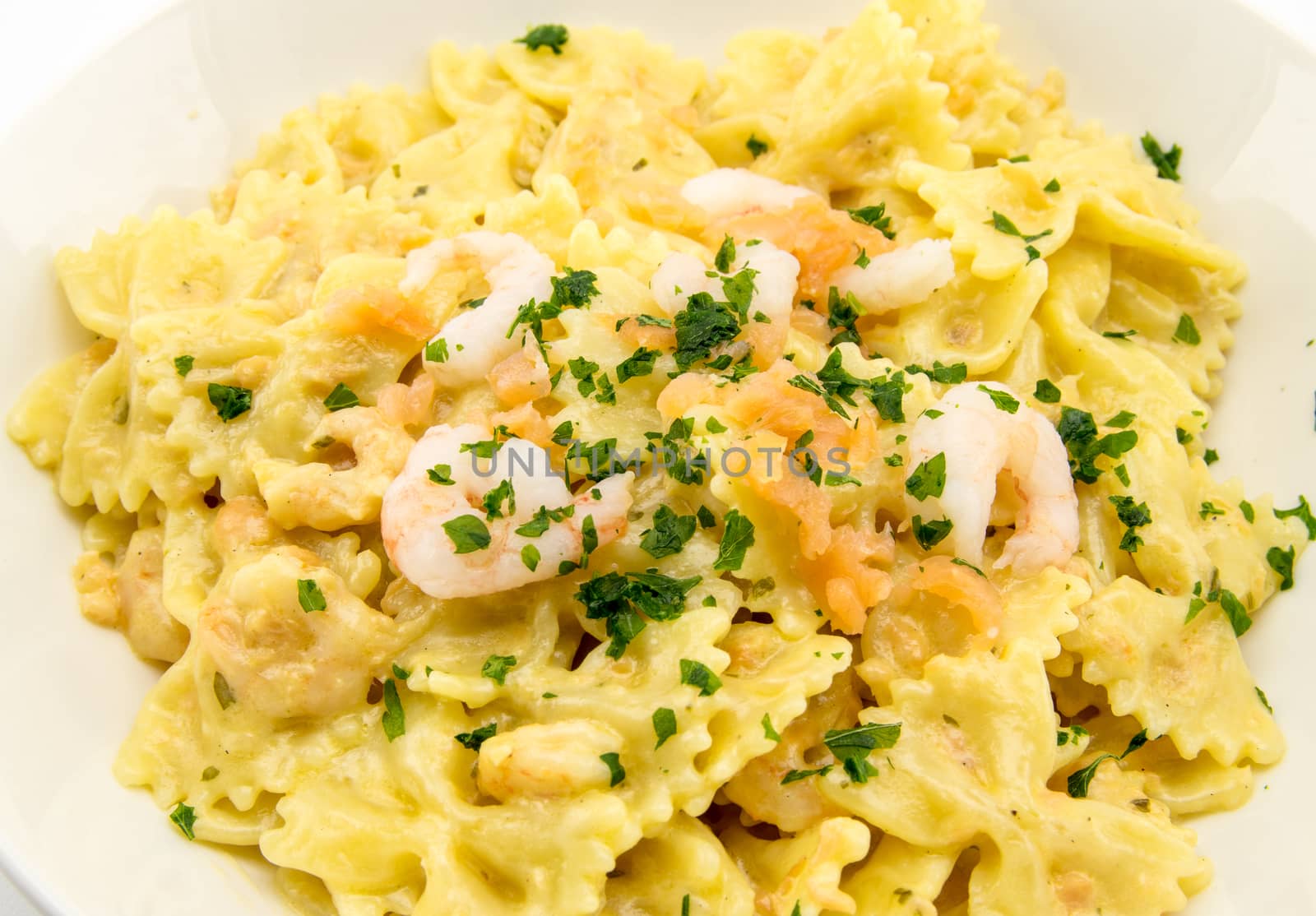 italian traditional pasta called butterflies with shrimp salmon and basil