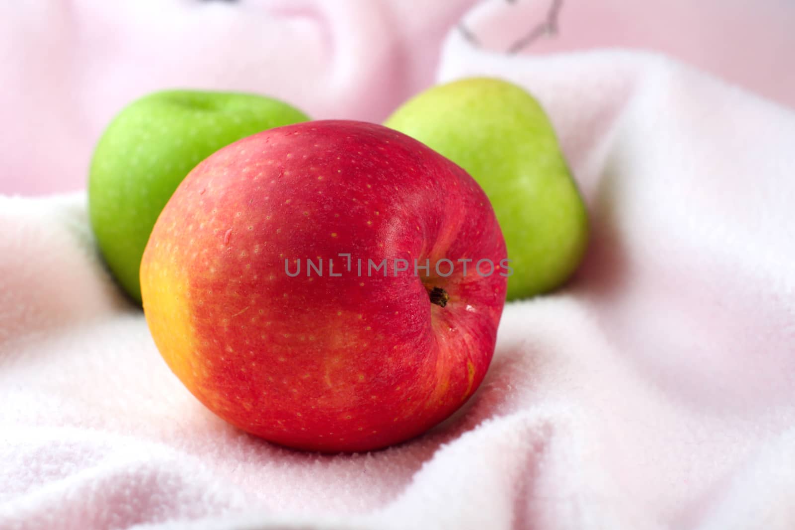 Red and green apple on pink cloth