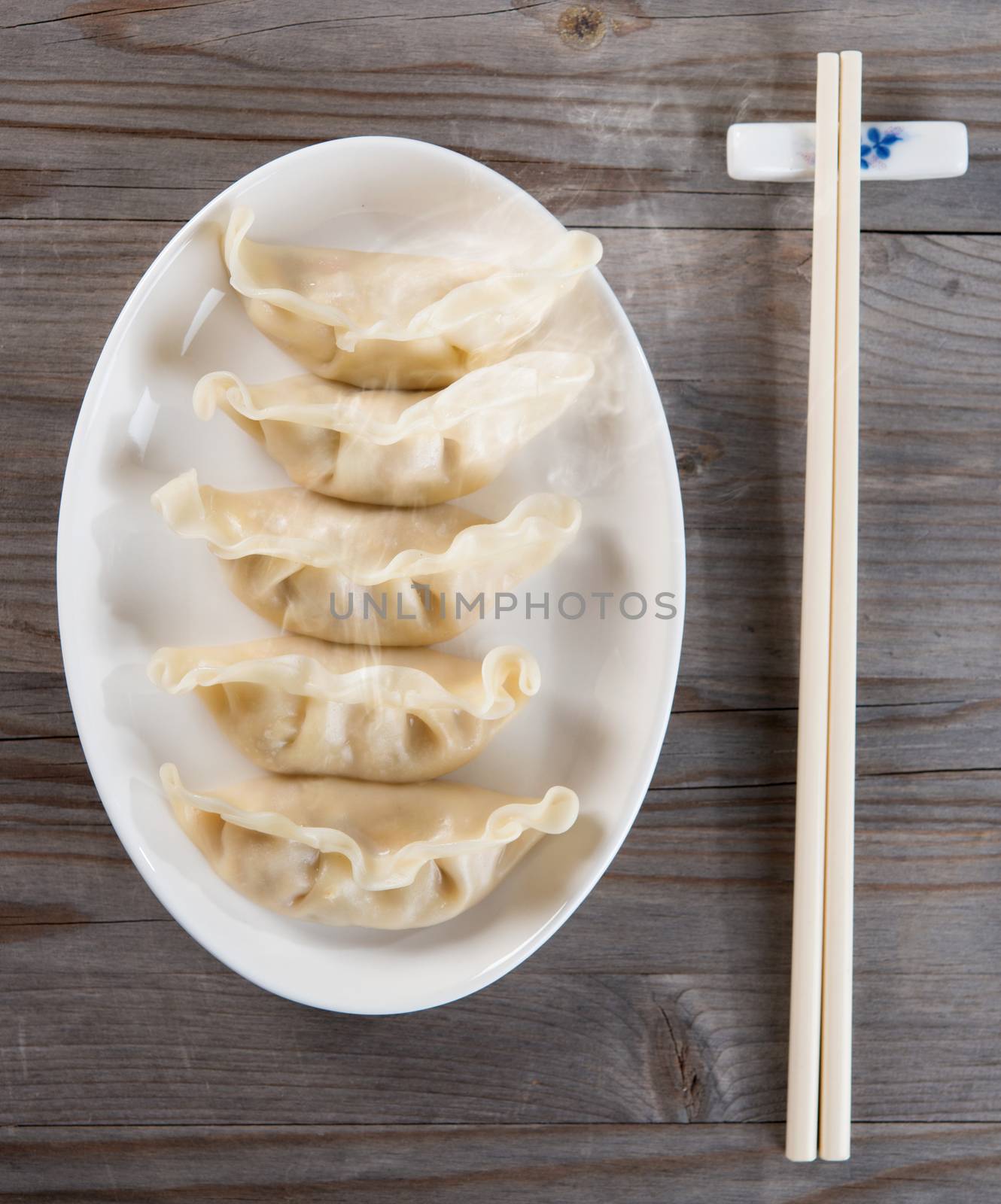 Top view fresh dumpling on plate with hot steams. Chinese food on old wooden background. 