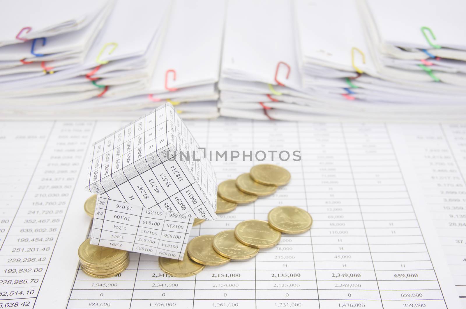 Bankruptcy of house with gold coins fall to the ground on finance account have step of paperwork as background.