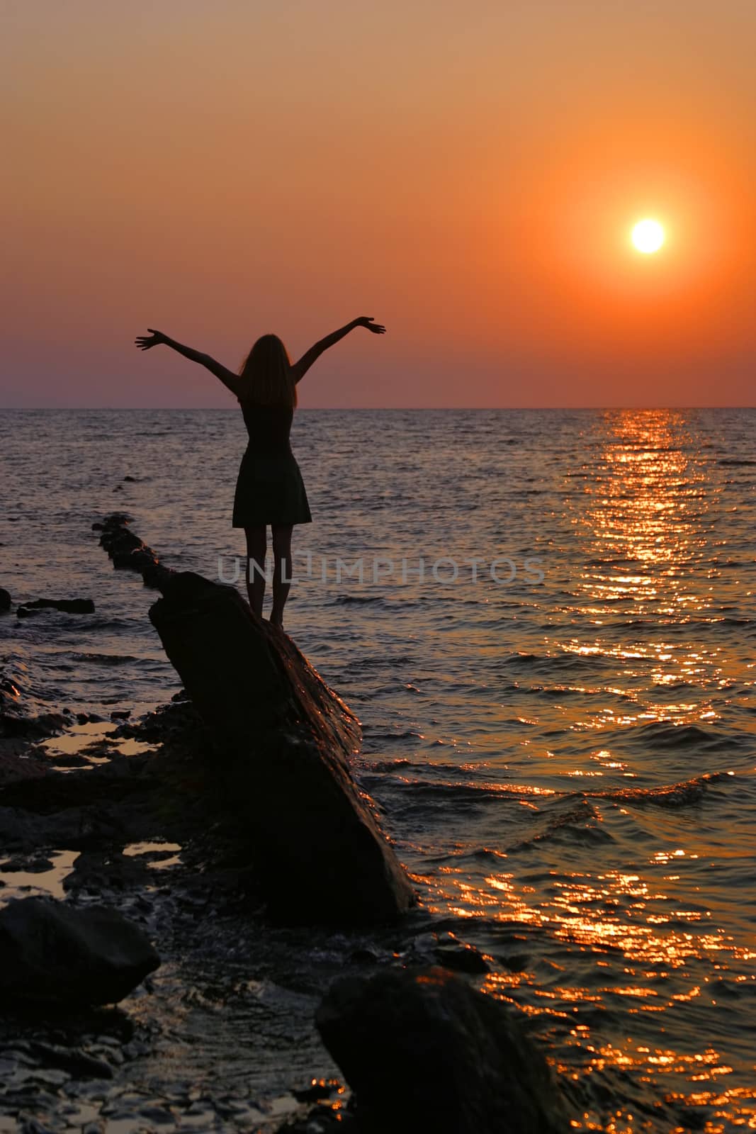 Beautiful sunset sky at summer evening with a silhouette of the woman. 