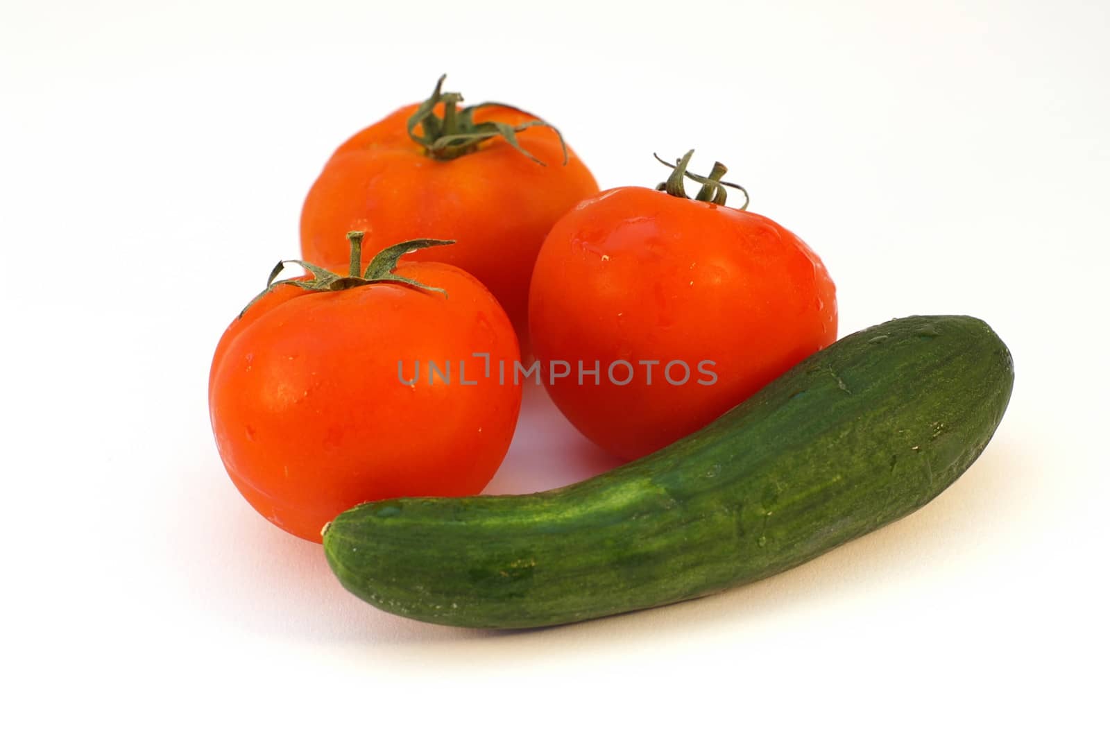 Fresh vegetables - cucumber and tomatoes on white background