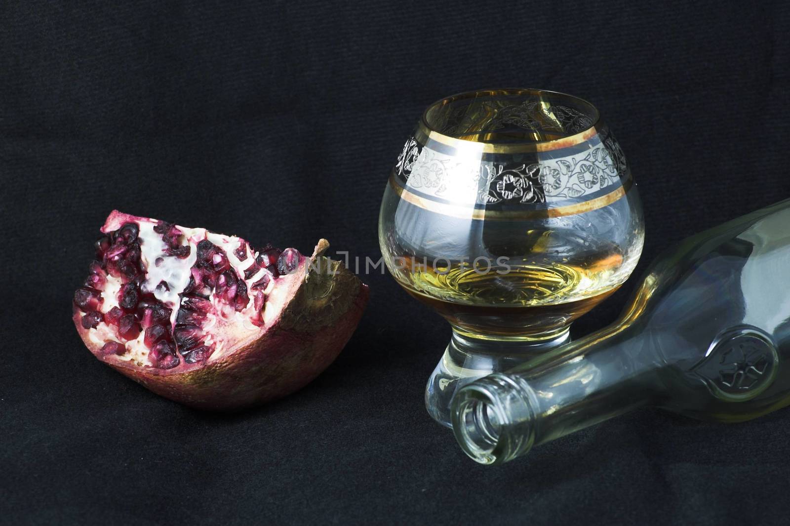 Pomengranate and cognac glass on a black background - food joy