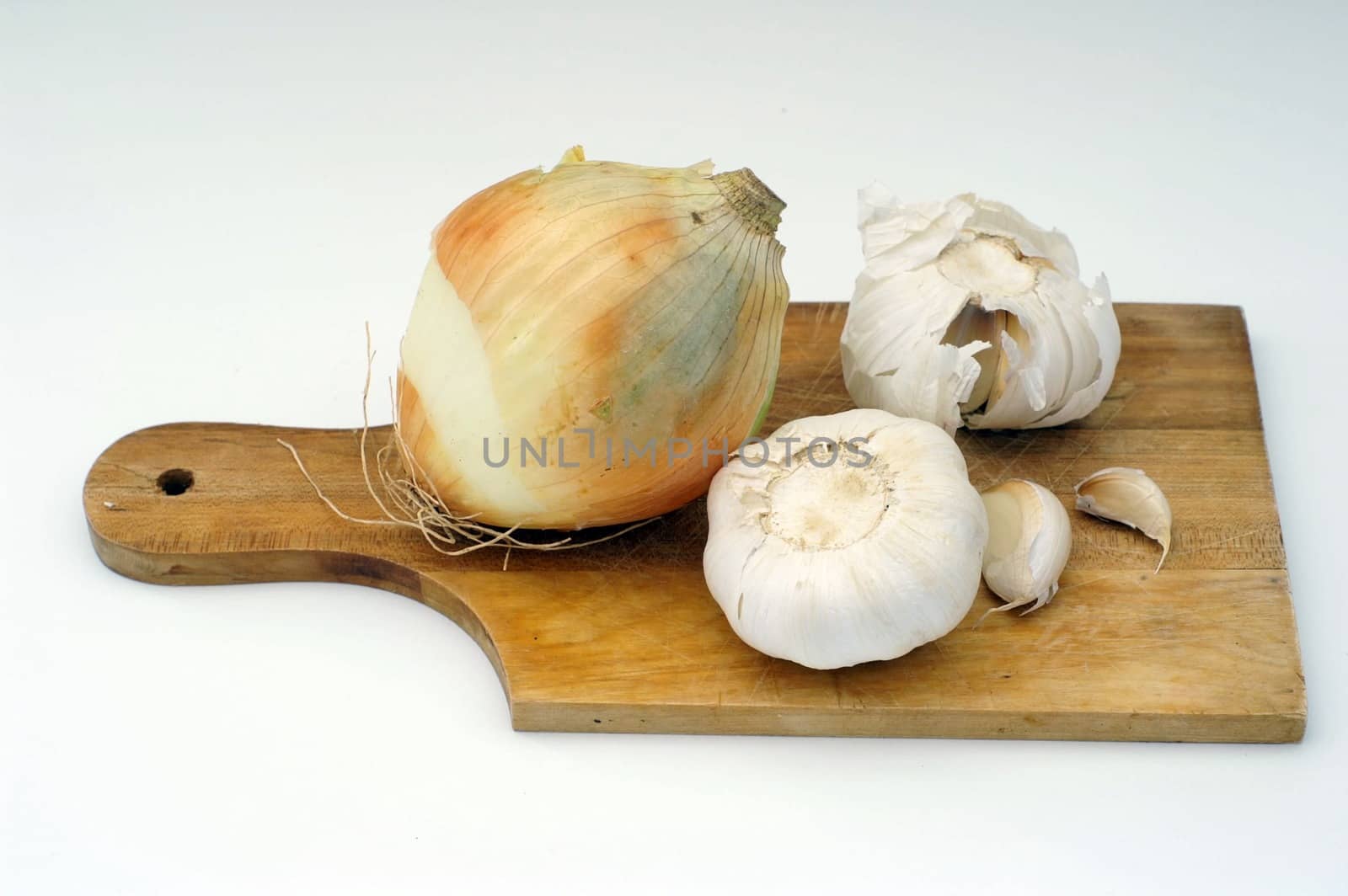 Garlic and onion on a wooden plate, isolated